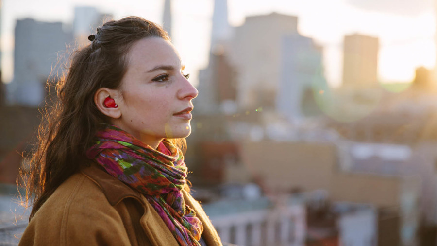 Young woman wearing pilot earplug translator