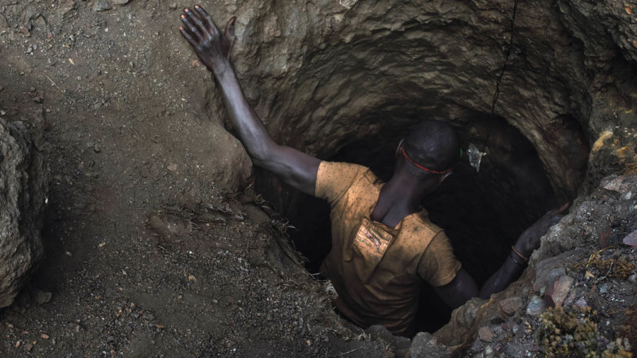 Mining employee, or creuseur, descends into a copper-cobalt mine in Kawama, Democratic Republic of the Congo, where conditions are dangerous with little to no safety equipment or structural support in the tunnels; they are paid on average $2 to $3 a day