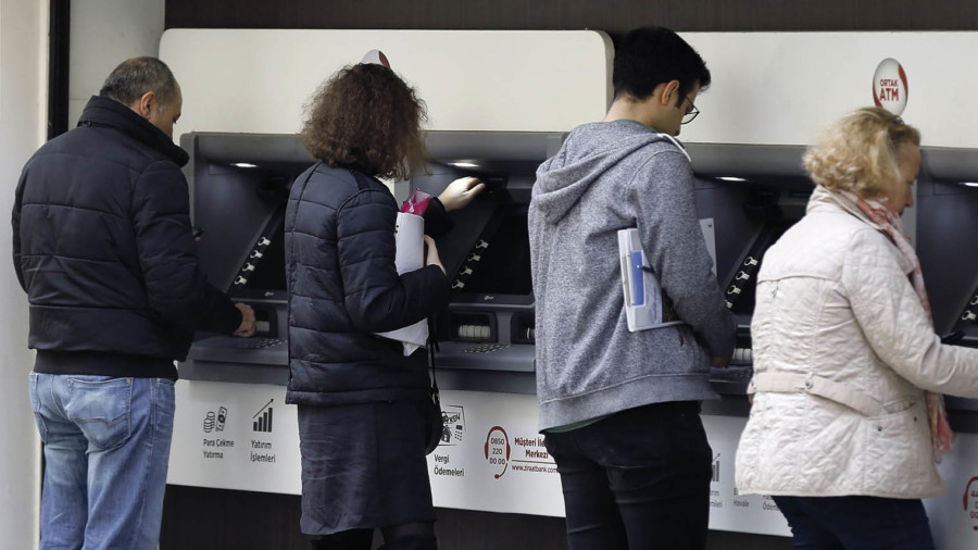 Customers taking out cash from cash machines