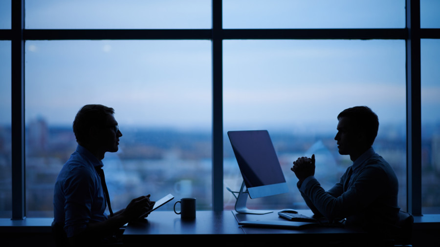 Two business executives talking against a city skyline
