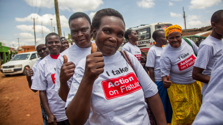 people wearing Action on Fistula t-shirts giving thumbs up