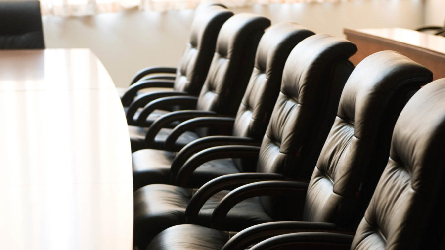 black office chairs facing a long desk