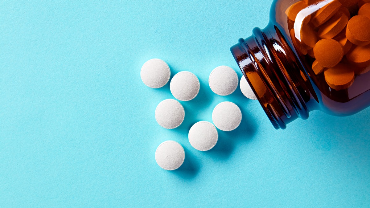 Bottle of pills on blue background
