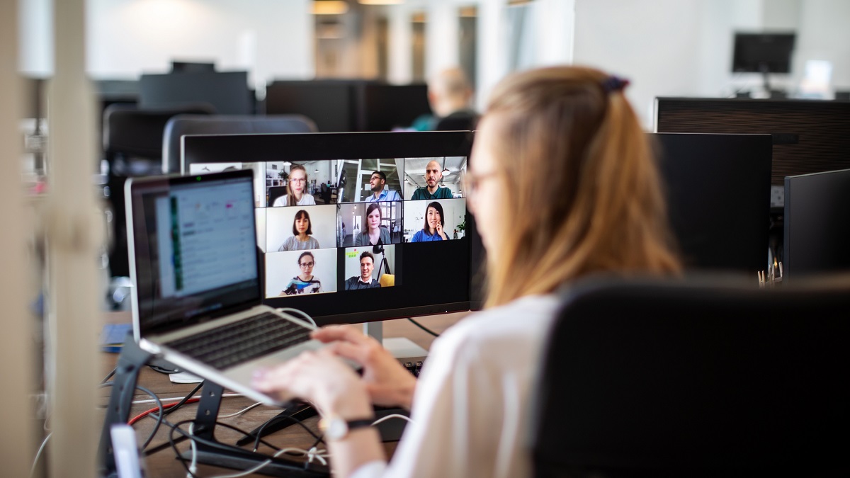 Woman in an office, on a video call with collegues