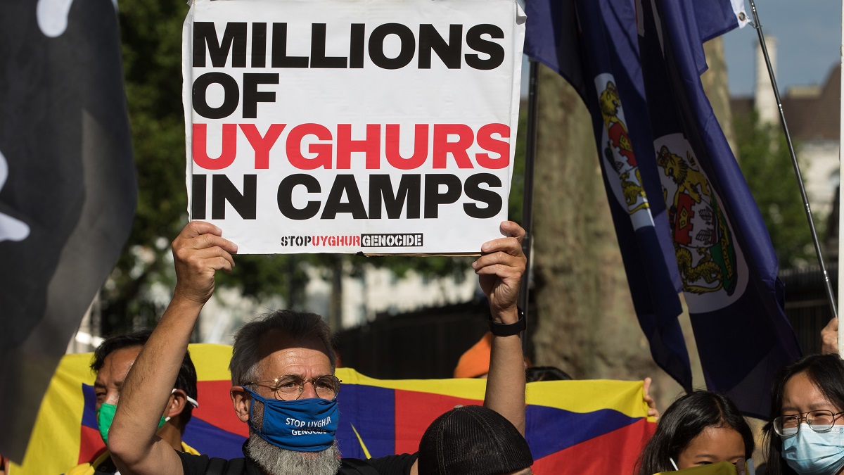 Man holds up sign protesting China's treatment of Uyghur Muslims