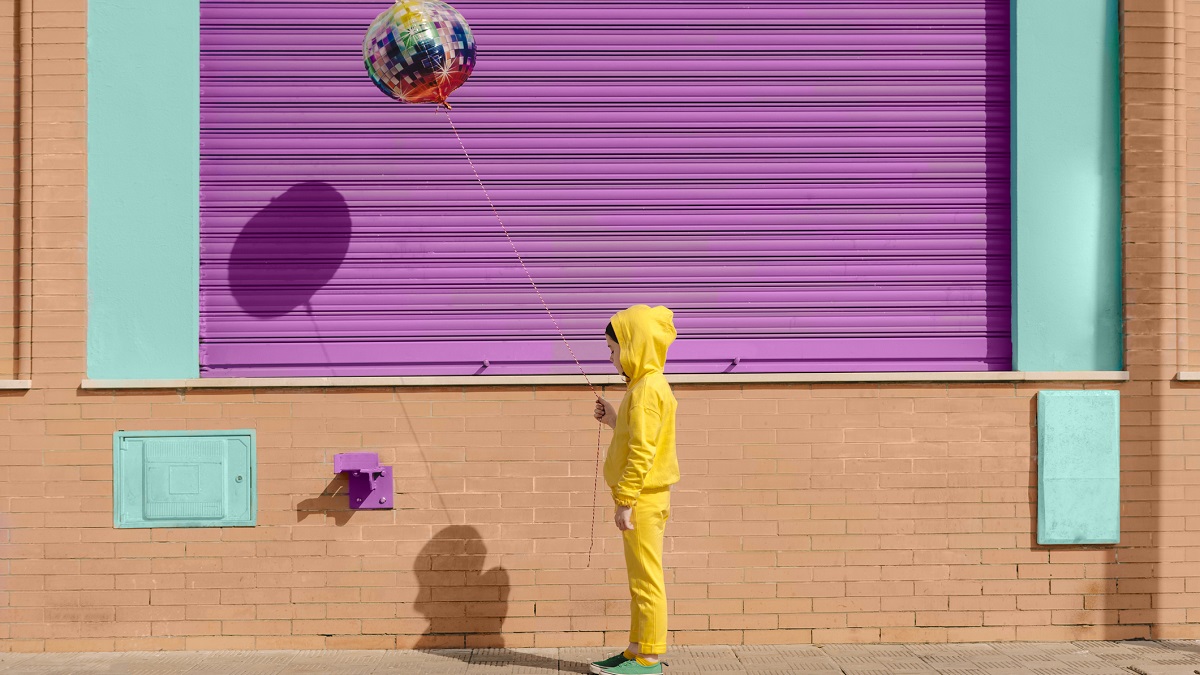 Little girl dressed in yellow with balloon