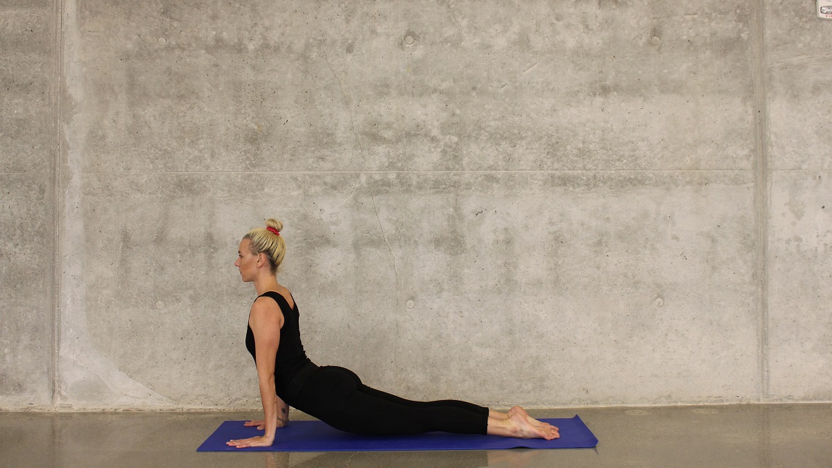 Woman in yoga pose against concrete wall