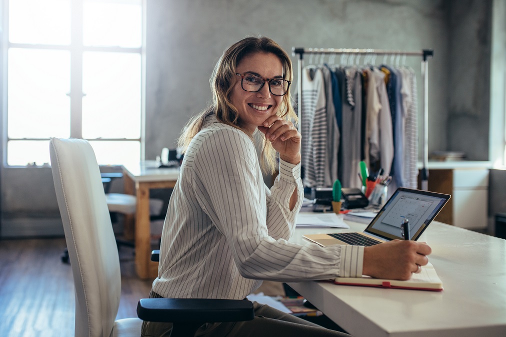 Smiling woman on a laptop at a desk