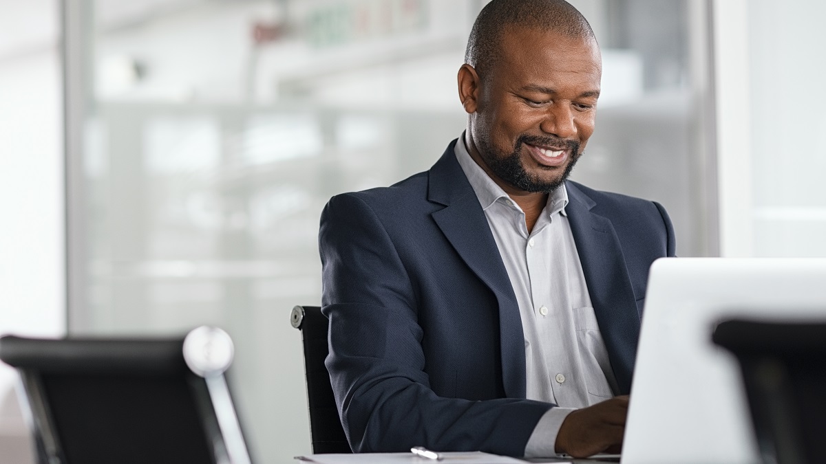Positive,Mature,Businessman,Working,On,Laptop,In,Modern,Office.,Successful