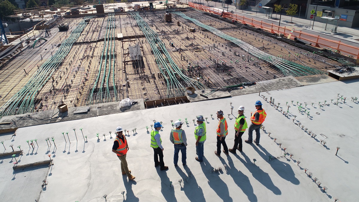 construction workers standing on edge of building